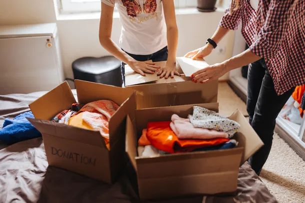 students packing clothes into boxes for moving