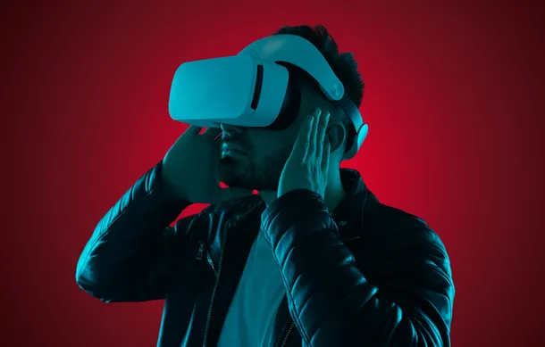 A person using a virtual reality headset against a red background.