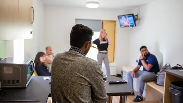 five students sitting in the shared living space within pontypridd accommodation, all talking