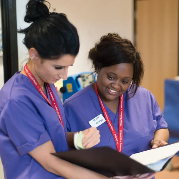 Two nursing students consulting paperwork together