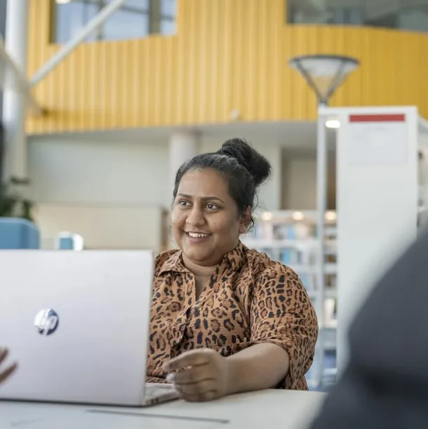 student sat at a table with laptop