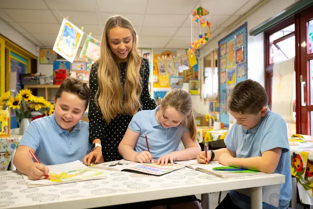USW student on placement, supervising three children colouring.
