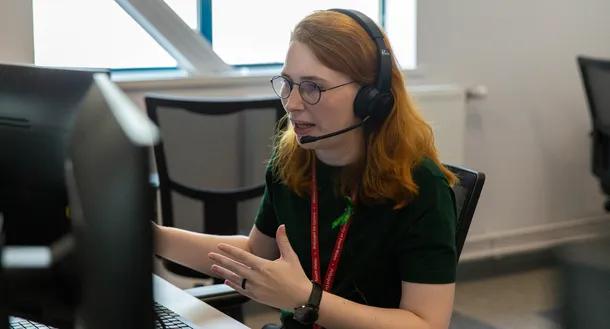 A member of USW staff taking a phone call through a headset.
