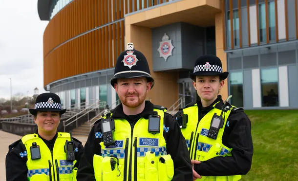 Three student police officers stand outside Gwent Police Headquarters