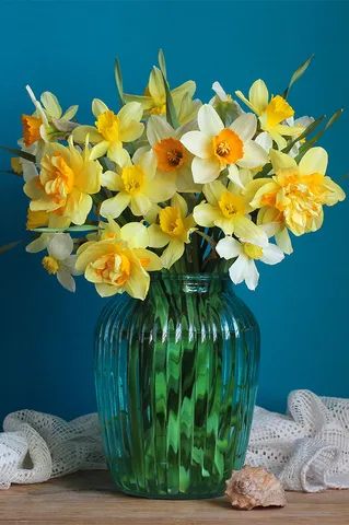 Bouquet of yellow daffodils in a glass vase on a table