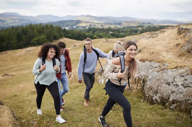 A group of friends hiking up a hill on a sunny day