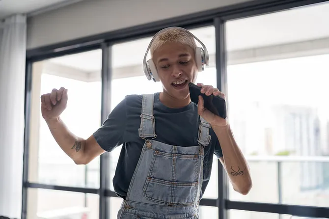 A student singing and holding a phone like a microphone with passion and joy