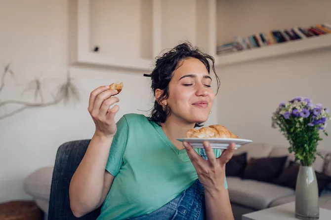 Young person enjoying their morning pastry at home