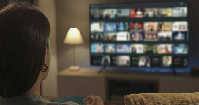 Woman relaxing in front of big screen TV