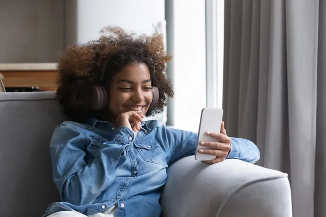 Student wearing headphones whilst using phone