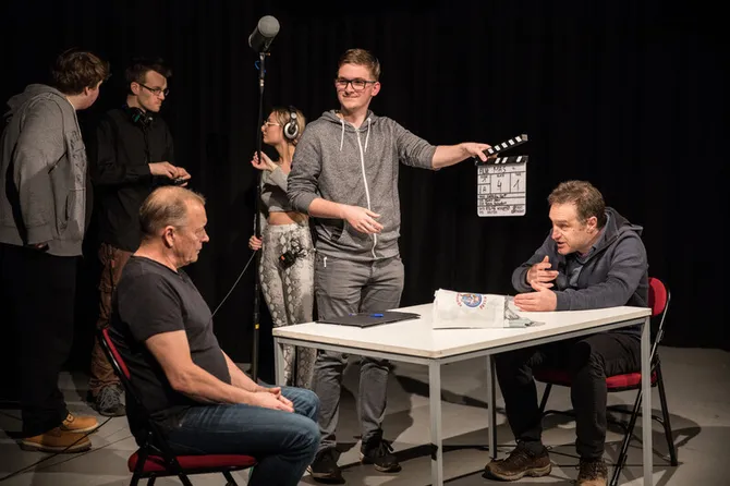 A group of students working together to film in the tv studio.