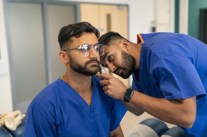 A Chiropractic student assessing another student.