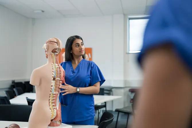 Chiropractic student with a model spine.