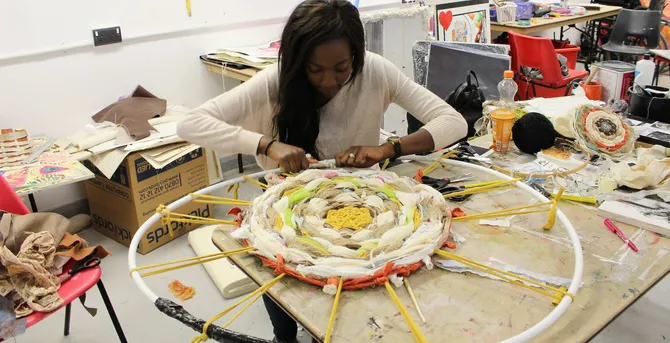 A student working on their art project in an art studio.