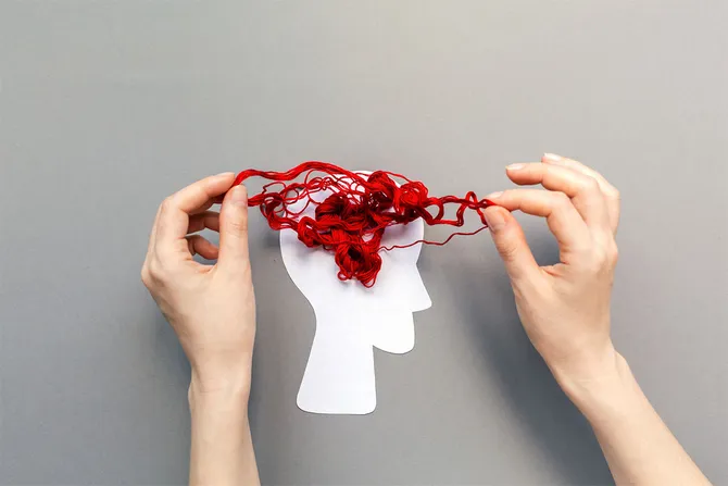 Tangled red threads on the silhouette of the head, representing the brain