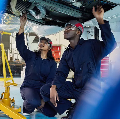 Two students working on a plan in an aircraft maintenance engineering workshop
