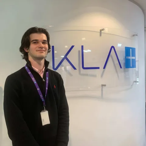 Network75 student Tom Lamb standing in front of KLA logo