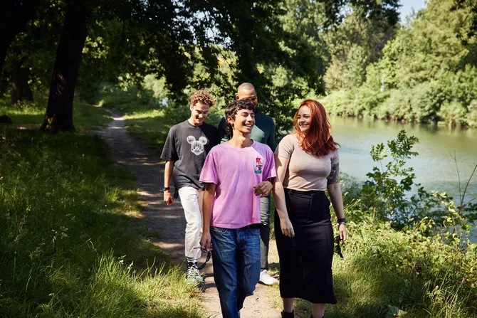 A group of students walking in Bute Park with the River Taff in the background.