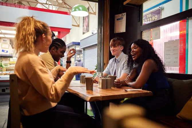 A group of students chatting over a coffee at a cosy cafe in Pontypridd Market