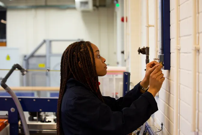 Civil engineering female student measuring something on a wall