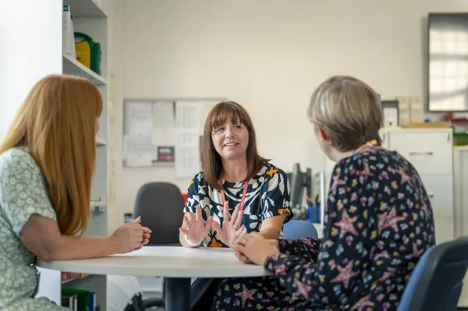 an acadmic is giving legal advice to two other people sat at a table.