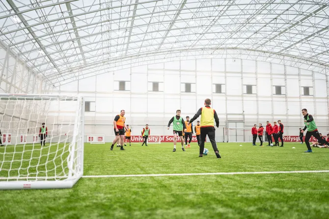A football match is taking place on the indoor pitch at USW Sport Park.