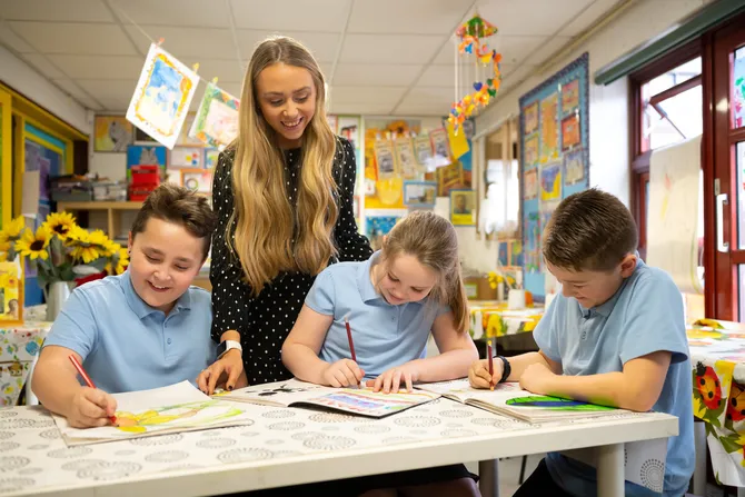 USW student on placement, supervising three children colouring.