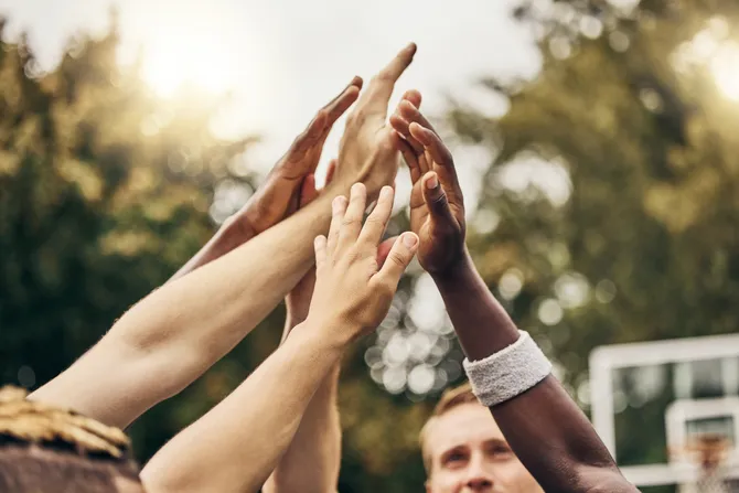 A group of people bringing their hands together as a team.