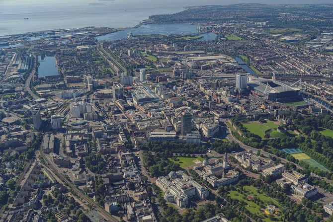 A wide aerial-view of the Cardiff city skyline including the Principality Stadium, Cardiff Bay and the green spaces within Cardiff