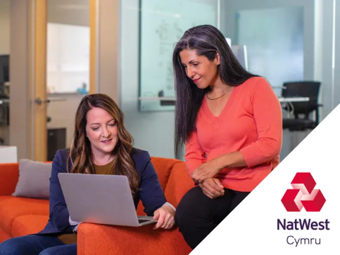 Bank advisor and customer sat on a sofa with a laptop