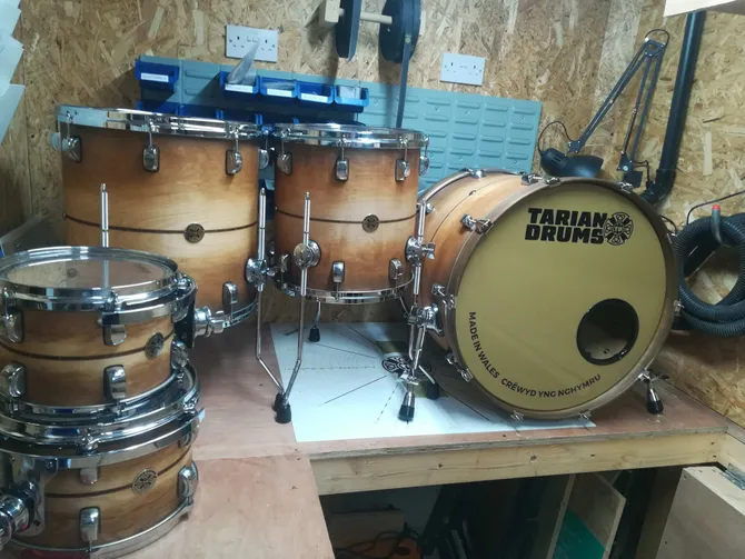 a brown wooden tarian drum set sitting on a work bench