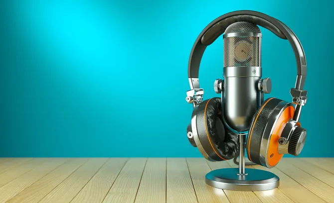 A microphone and headphones resting on a wooden table