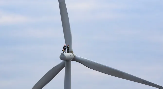 two engineers standing on a wind turbine