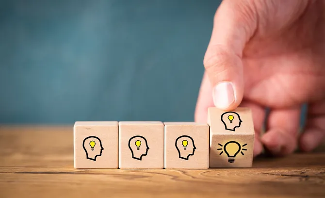 many people together having an idea symbolized by icons on cubes on wooden background
