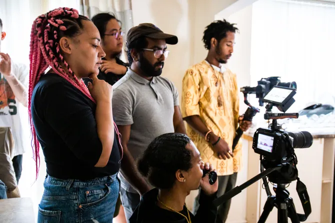 Members of Urban Circle gathered around a film camera.