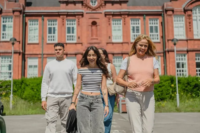 Students walking together with Glyntaff campus in the background.