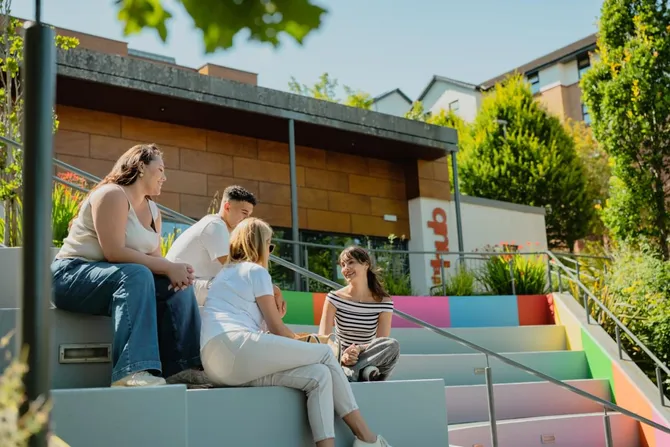 A group of open day visitors sat on the steps outside the accommodation hub