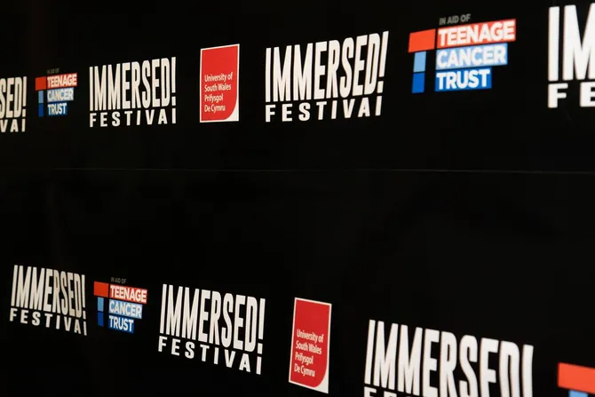Wall of a building covered in logs of Immersed Festival and USW