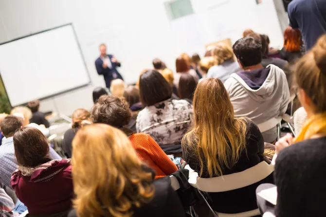 An academic presents to a lecture theatre full of people