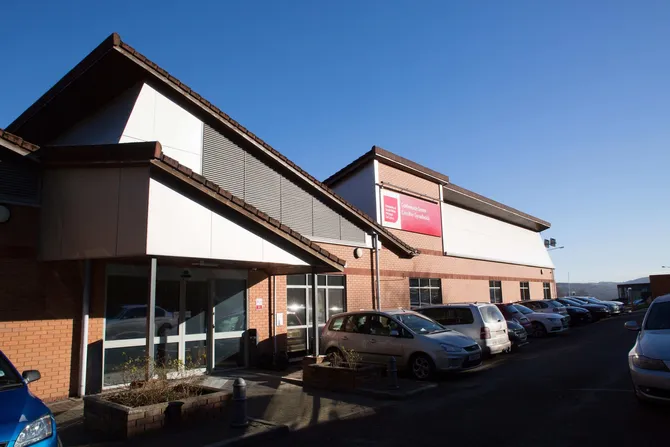 The entrance to the Conference Centre and its carpark against a blue sky