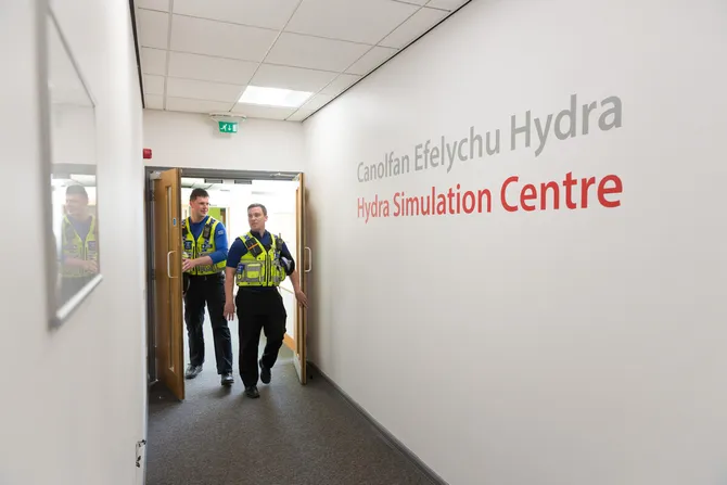 Police in uniform walking through the University's Hydra Simulation Centre.