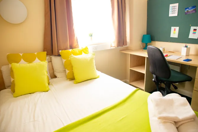 A double room with a comfy bed, a desk, and a chair