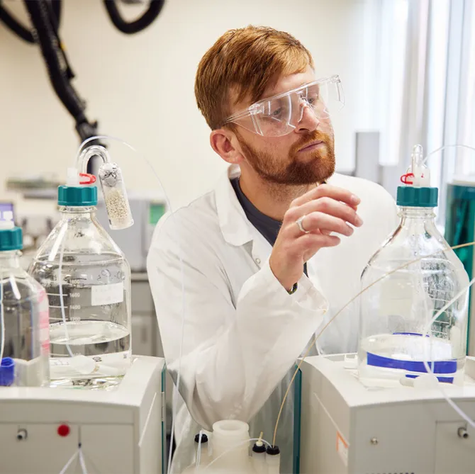 A student using pharmaceutical science equipment in a classroom