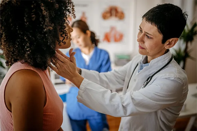 Female doctor examining the throat of a female patient in a GP practice