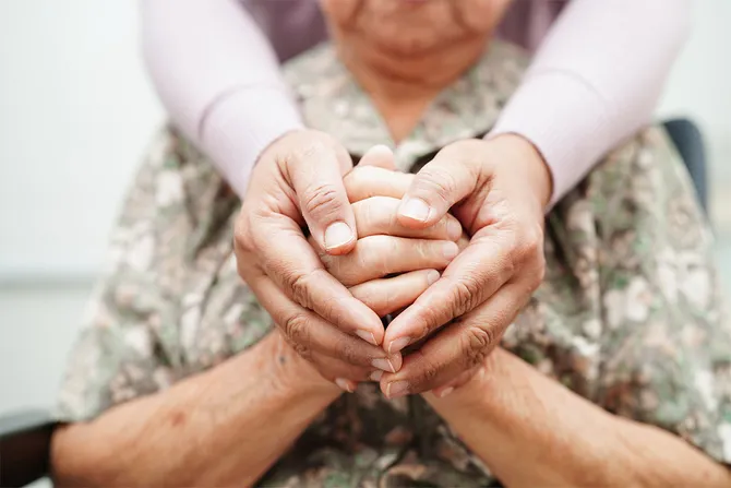 Caregiver holding the hands of an elderly patient