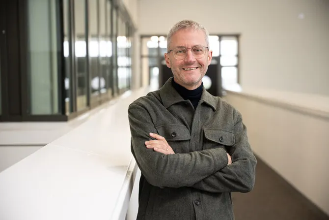 professor chris evans standing in Cardiff Campus building smiling