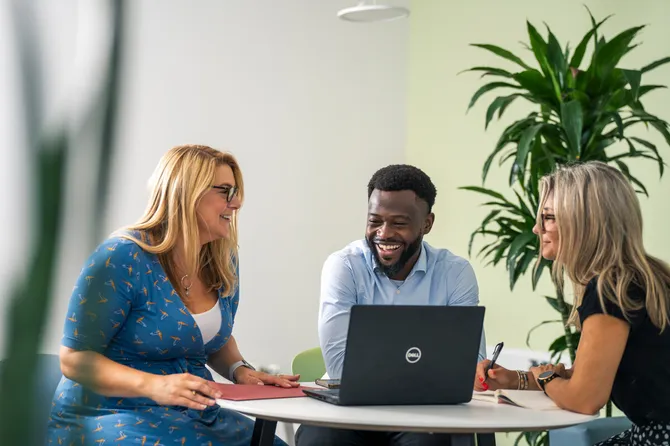 three members of university staff having an informal meeting, smiling