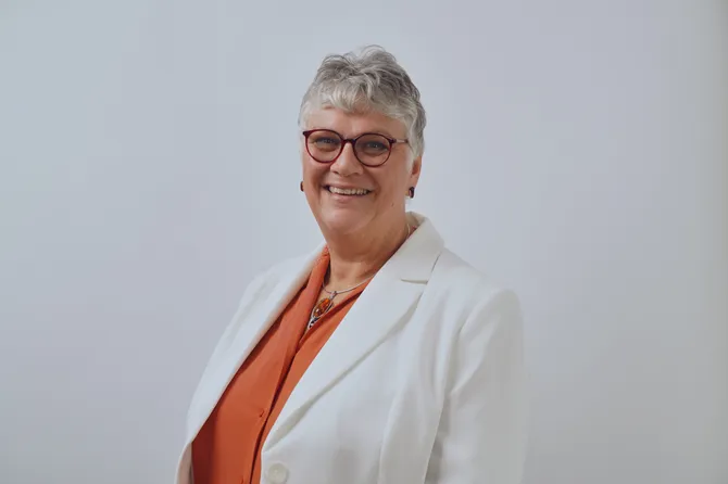 A professional photograph of Louise Evans smiling at the camera.