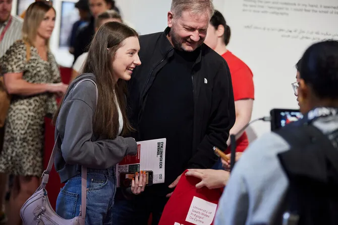 USW open day visitors smiling as they interact with staff.