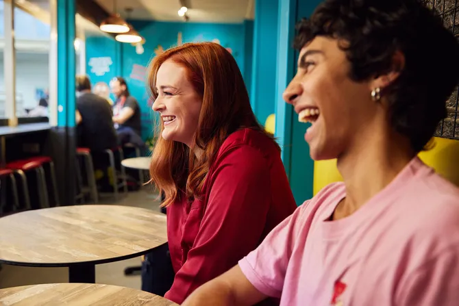 Two students smiling in a restaurant.
